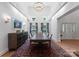 Bright dining room featuring a long table with seating for eight, a stylish chandelier, and hardwood floors at 8433 Cheverny Dr, Waxhaw, NC 28173