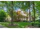 Beautiful two-story home framed by mature trees, features a stone accent and a charming front porch at 8433 Cheverny Dr, Waxhaw, NC 28173