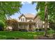 Charming two-story home with a stone and siding exterior, a welcoming front porch, and manicured landscaping at 8433 Cheverny Dr, Waxhaw, NC 28173