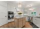 Bright kitchen with marble counters, white custom cabinets, stainless appliances, pendant lighting and hardwood floors at 8433 Cheverny Dr, Waxhaw, NC 28173