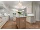 Spacious gourmet kitchen featuring marble countertops, stainless appliances, custom cabinets and hardwood floors at 8433 Cheverny Dr, Waxhaw, NC 28173