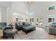 Bright living room featuring high ceilings, hardwood floors, and a view of the backyard pool through french doors at 8433 Cheverny Dr, Waxhaw, NC 28173