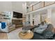 Cozy living room features a stone fireplace, built-in shelving, and comfortable seating beneath a soaring ceiling at 8433 Cheverny Dr, Waxhaw, NC 28173
