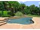 Backyard pool features stone accents, lush landscaping, creating a serene and private outdoor space at 8433 Cheverny Dr, Waxhaw, NC 28173