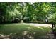 Lush backyard featuring a storage shed nestled among mature trees and a well-maintained lawn at 8618 Rittenhouse Cir, Charlotte, NC 28270