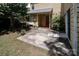Backyard view with a concrete patio, mature landscaping, and a home exterior with a red door at 8618 Rittenhouse Cir, Charlotte, NC 28270