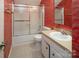 Bathroom featuring a shower and tub combination with ornate red wallpaper and a vanity with sink at 8618 Rittenhouse Cir, Charlotte, NC 28270
