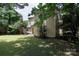 Rear view of a two-story home with siding, a grassy yard, and mature trees surrounding the property at 8618 Rittenhouse Cir, Charlotte, NC 28270