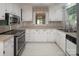 Bright kitchen with white cabinets, a stainless steel range, and laminate countertops at 8618 Rittenhouse Cir, Charlotte, NC 28270