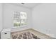 Bedroom featuring a window, a small dresser, an accent rug, and neutral walls at 8722 Heron Glen Dr, Charlotte, NC 28269
