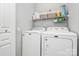Bright laundry area showcasing a washer, dryer, and built-in shelving for storage at 8722 Heron Glen Dr, Charlotte, NC 28269