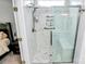 Modern glass shower with marble tiles, built-in shelving, and convenient seating at 8722 Heron Glen Dr, Charlotte, NC 28269