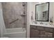 Bathroom features gray tiling in the tub, shower, and a gray vanity with a white countertop, and black framed mirror at 1006 Gradison Dr, Matthews, NC 28104