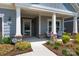 Inviting front porch features classic columns, comfortable seating, and decorative landscaping for relaxed outdoor living at 1006 Gradison Dr, Matthews, NC 28104