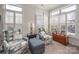 Cozy sitting room with comfortable seating and bright light coming in from the many windows with white plantation shutters at 1006 Gradison Dr, Matthews, NC 28104