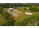 Aerial view of property featuring vast green land, commercial building, and parking, surrounded by lush trees at 1028 Washburn Switch Rd, Shelby, NC 28150