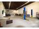 Open garage area with vehicle lift, work benches and storage at 1028 Washburn Switch Rd, Shelby, NC 28150