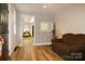 Cozy living room with wood flooring, comfortable brown sofa, and view into another room at 1028 Washburn Switch Rd, Shelby, NC 28150