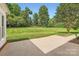 View of the backyard from a concrete patio featuring a well-manicured lawn and mature trees at 1185 Willow Creek Dr, Newton, NC 28658
