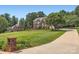 Expansive front lawn with brick mailbox, mature trees, and brick home in the background, offering a serene setting at 1185 Willow Creek Dr, Newton, NC 28658