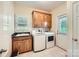 Laundry room with granite countertop, tile flooring, cabinets, a sink, and modern washer and dryer units at 1185 Willow Creek Dr, Newton, NC 28658