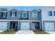 Charming townhome features a one car garage, craftsman style doors and a beautiful blue exterior at 1423 Old Rivers Rd, Concord, NC 28027