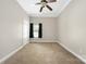 A empty room features a neutral color palette, carpet flooring, and a ceiling fan at 15024 Old Vermillion Dr, Huntersville, NC 28078