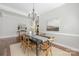 Elegant dining room featuring hardwood floors, a chandelier, and a rustic dining table with seating at 15024 Old Vermillion Dr, Huntersville, NC 28078