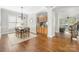 Open-concept dining area with hardwood floors, adjacent to a built-in bar and bright living space at 15024 Old Vermillion Dr, Huntersville, NC 28078