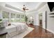 This main bedroom features hardwood floors, a ceiling fan, and lots of natural light at 15024 Old Vermillion Dr, Huntersville, NC 28078