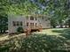 View of the back of the home with a deck and well-maintained lawn, surrounded by trees at 155 Culpeze Rd, Mooresville, NC 28117