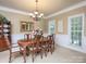 Elegant dining room with a chandelier, large windows, and a wooden table with upholstered chairs at 155 Culpeze Rd, Mooresville, NC 28117