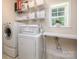 Organized laundry room with washer, dryer, shelving, and a window at 155 Culpeze Rd, Mooresville, NC 28117