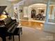 Open-concept living room with a piano, wood floors, and a view into the dining room and kitchen at 155 Culpeze Rd, Mooresville, NC 28117
