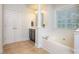 Bright bathroom featuring tile floors, a soaking tub, decorative pillars, and a large storage closet at 155 Culpeze Rd, Mooresville, NC 28117