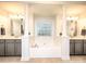 Bright main bathroom with dual vanities, modern fixtures, tile floors, and a large soaking tub at 155 Culpeze Rd, Mooresville, NC 28117