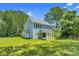 Backyard view of two-story blue home, with a lush lawn and mature trees at 1651 Carolina Cir, Gastonia, NC 28054