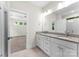 Bathroom with double vanity, white cabinets, granite countertop, and adjoining bedroom at 1651 Carolina Cir, Gastonia, NC 28054