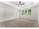 Bright bedroom featuring a tray ceiling, carpeted floors, and three windows providing natural light at 1651 Carolina Cir, Gastonia, NC 28054