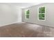 Bedroom featuring two windows offering outside views and neutral carpeting throughout at 1651 Carolina Cir, Gastonia, NC 28054