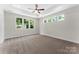 Spacious bedroom with tray ceiling, carpeted floors and an abundance of natural light from multiple windows at 1651 Carolina Cir, Gastonia, NC 28054