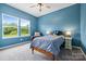 A cozy bedroom with natural light, complimented by neutral carpet, blue walls, and a quaint side table at 196 Sutters Mill Dr, Troutman, NC 28166