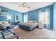 Spacious primary bedroom featuring serene blue walls, a ceiling fan, and ample natural light from curtained windows at 196 Sutters Mill Dr, Troutman, NC 28166