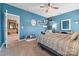 Charming bedroom with blue walls, complemented by decor shelves, a mirror, and natural light from a nearby door at 196 Sutters Mill Dr, Troutman, NC 28166