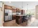 Kitchen with stainless steel appliances, dark wood cabinets, and a center island with bar stools at 196 Sutters Mill Dr, Troutman, NC 28166