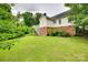 A spacious backyard with lush lawn, mature trees, and brick house foundation at 2132 Cubla Ct, Rock Hill, SC 29732