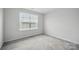 Bright bedroom featuring neutral walls, plush carpeting, and a large window for ample natural light at 223 Haddonsfield Dr, Mooresville, NC 28115