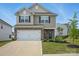Charming two-story home featuring a stone-accented facade, attached garage, and well-maintained landscaping at 223 Haddonsfield Dr, Mooresville, NC 28115