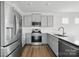 Modern kitchen boasts stainless steel appliances, gray cabinets, and wood-look floors at 223 Haddonsfield Dr, Mooresville, NC 28115