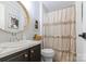 Bathroom with a round mirror, light brown cabinets, and shower with a decorative shower curtain at 2932 Rant Drum Rd, Maiden, NC 28650